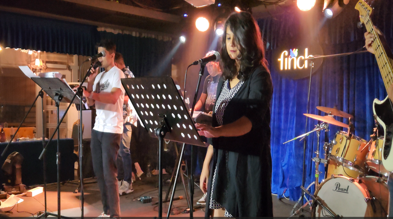 JBX Band performing for a large crowd at an indoor venue